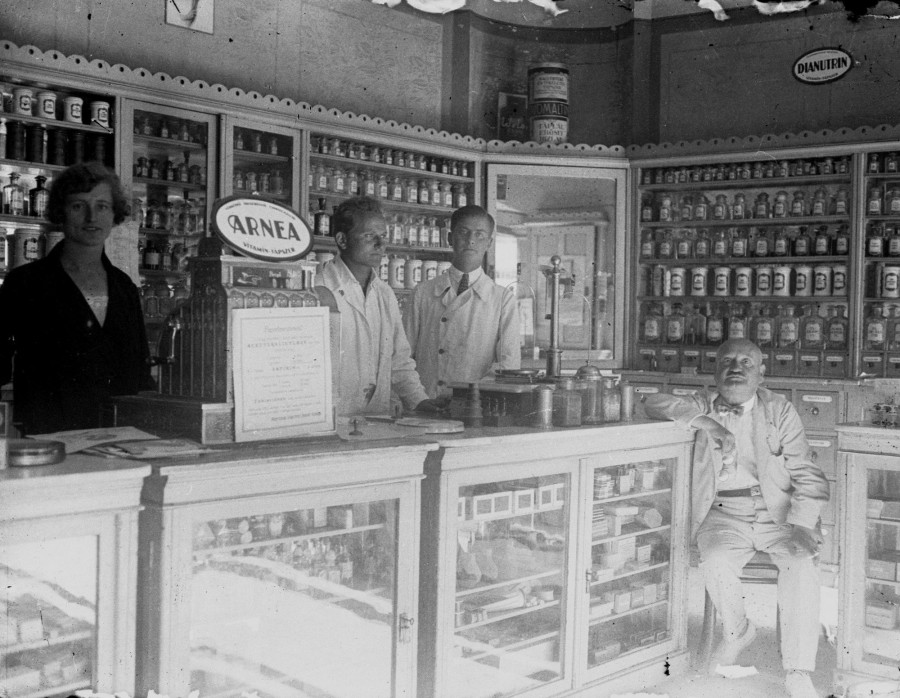  A patika a régi, fehér berendezéssel, balról jobbra: egy asszisztens, Kocsuba Elemér, Karabélyos Endre és Kocsuba Emil az 1920-as években. #57192 Fotó: Fortepan / Karabélyos Péter