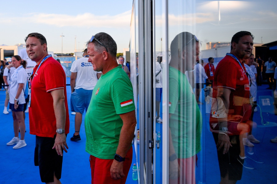 . Szájer Péter csapatvezető (b) és Gellért Gábor, a nyíltvízi úszók szövetségi kapitánya (b2) távozik a versenyirodából a nyíltvízi úszók 25 kilométeres, kedvezőtlen időjárás miatt megállított versenye után a római vizes Európa-bajnokságon Ostiában 2022. augusztus 20-án. Nem hirdettek végeredményt a versenyen. MTI/Czeglédi Zsolt