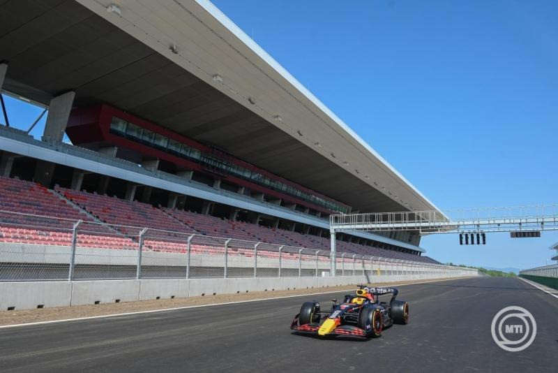 A Red Bull egyik Forma-1-es versenyautója a megújult főlelátó előtt a Hungaroringen, a mogyoródi versenypálya felújított épületeit bemutató sajtótájékoztató napján, 2025. június 19-én. MTI/Máthé Zoltán