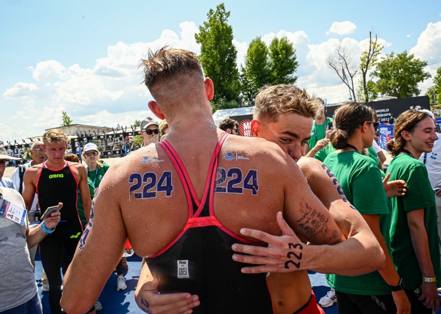 Rasovszky Kristóf (háttal) és Betlehem Dávid, a második helyezett magyar váltó tagjai összeölelkeznek a nyíltvízi úszók csapatversenye után a budakalászi Lupa-tónál 2022. június 26-án. MTI/Szigetváry Zsolt